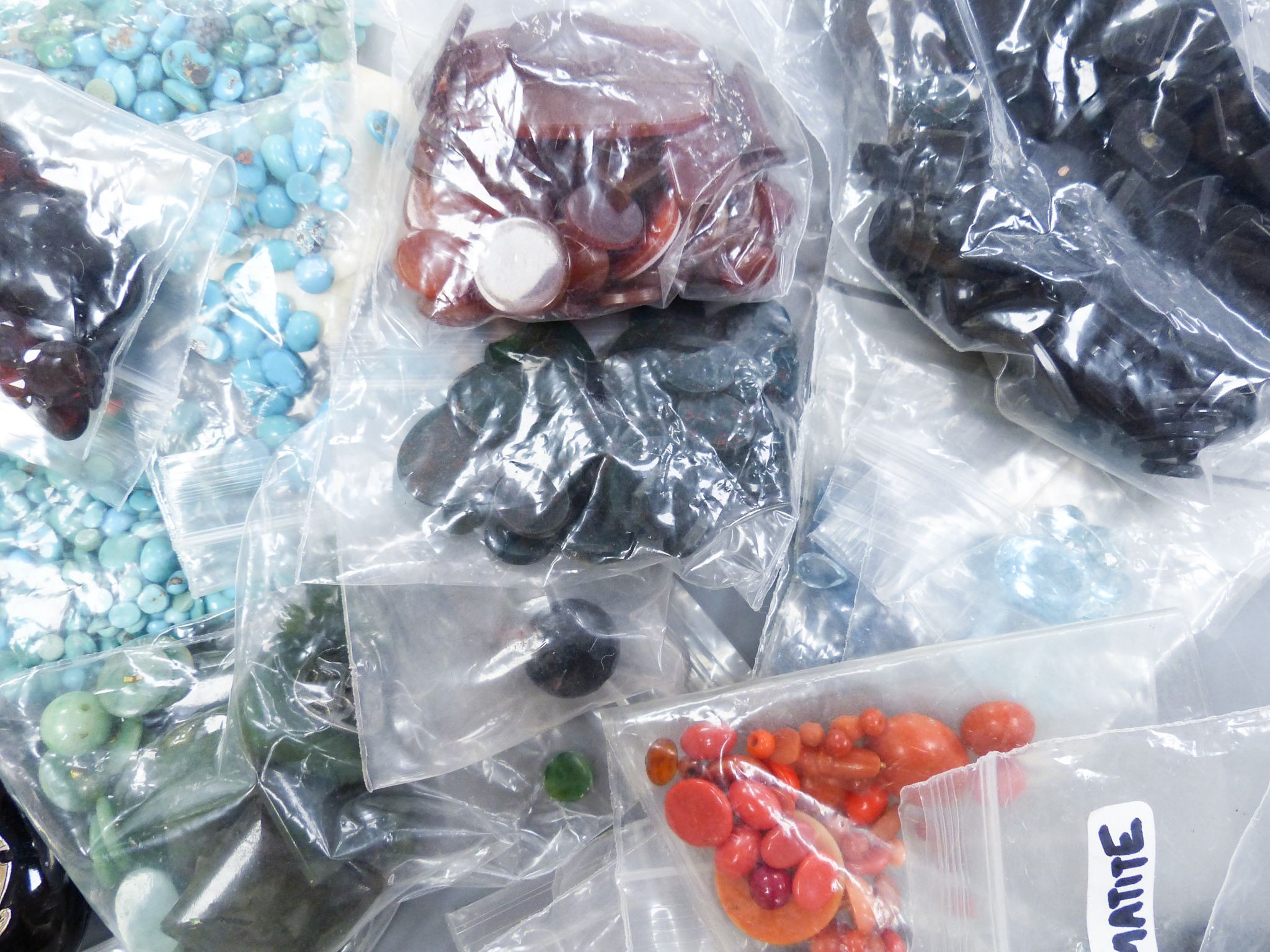 A quantity of assorted unmounted gemstones including, opal, opal doublet, malachite, chalcedony, tiger's eye quartz, hematite, etc.